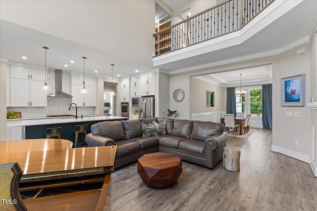 1809 Bowling Rd, Fuquay Varina, NC 27526 - living room featuring wood finished floors, a chandelier, recessed lighting, ornamental molding, and a high ceiling