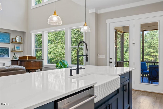 1809 Bowling Rd, Fuquay Varina, NC 27526 - kitchen featuring dishwasher, light wood-type flooring, decorative light fixtures, blue cabinets, and open floor plan