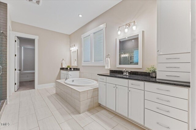 1809 Bowling Rd, Fuquay Varina, NC 27526 - full bathroom with tile patterned flooring, two vanities, a garden tub, and a shower stall