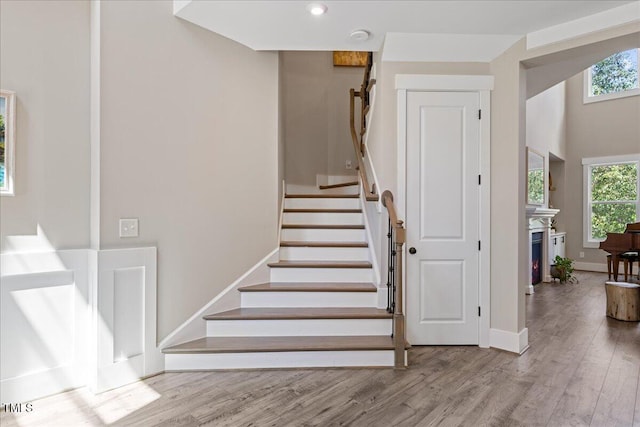1809 Bowling Rd, Fuquay Varina, NC 27526 - stairs with plenty of natural light, wood finished floors, recessed lighting, and a warm lit fireplace