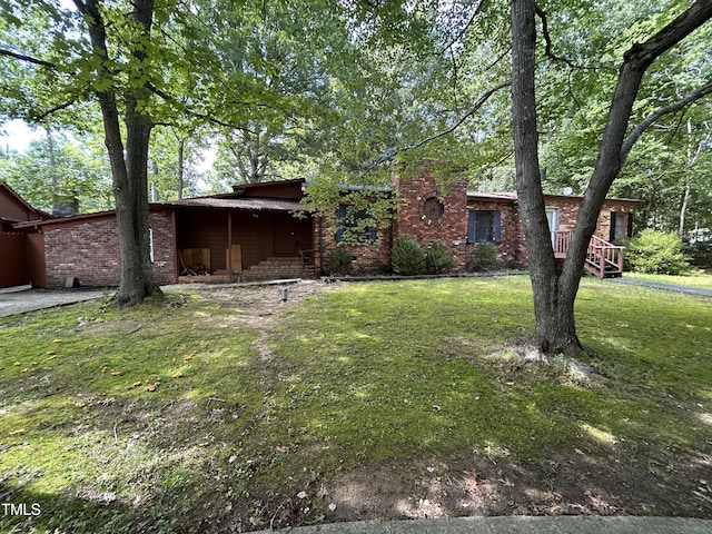 194 John Mitchell Rd, Youngsville, NC 27596 - view of front facade featuring a front yard, a chimney, and brick siding