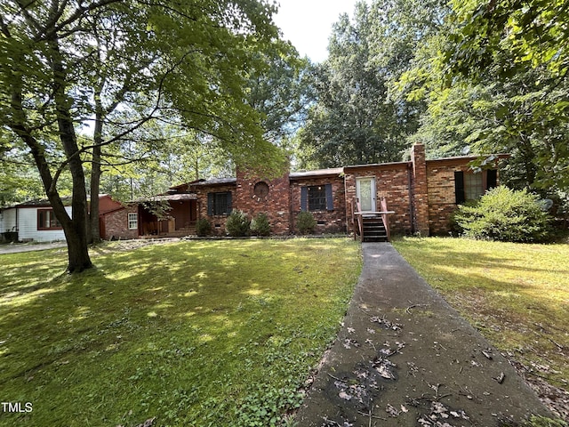 194 John Mitchell Rd, Youngsville, NC 27596 - view of front of house with a front lawn, brick siding, and a chimney
