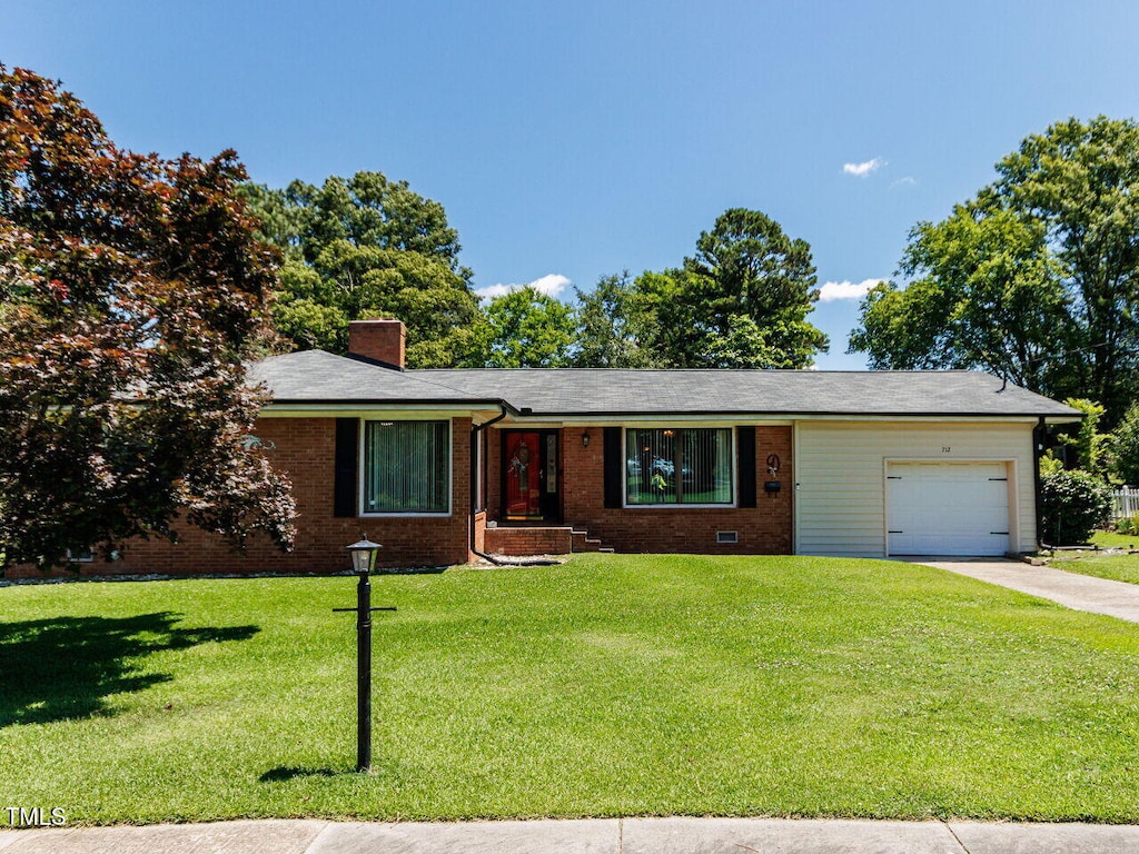 712 E Horne St, Clayton, NC 27520 - ranch-style home featuring an attached garage, driveway, a front lawn, a chimney, and brick siding