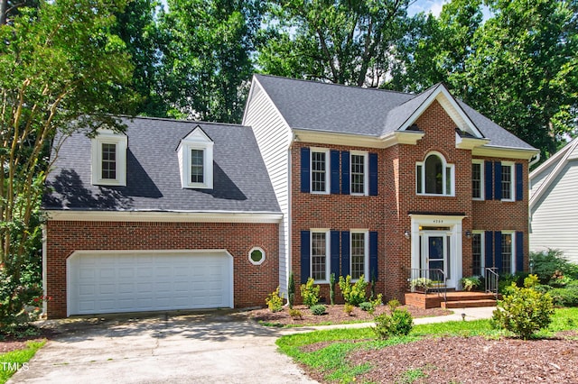 4309 Omni Pl, Raleigh, NC 27613 - view of front of home featuring driveway, brick siding, an attached garage, and roof with shingles