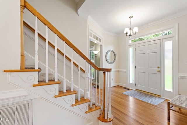 4309 Omni Pl, Raleigh, NC 27613 - foyer featuring a chandelier, wood finished floors, stairs, and ornamental molding