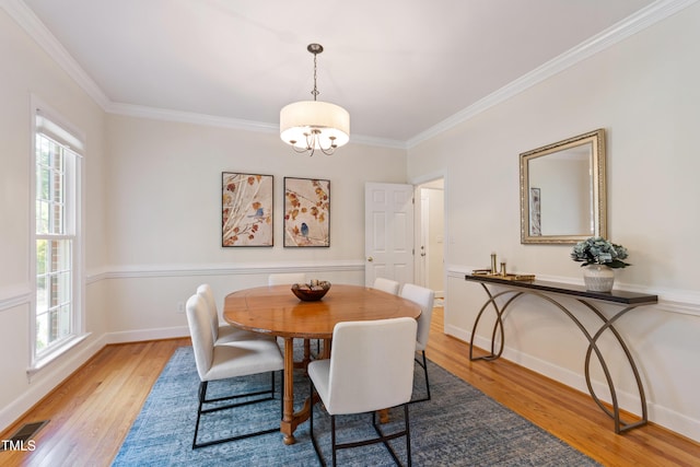 4309 Omni Pl, Raleigh, NC 27613 - dining space featuring light wood-style floors, crown molding, and a chandelier