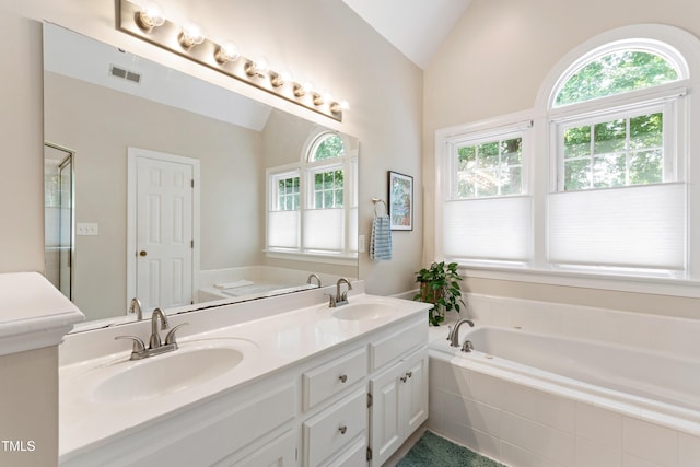 4309 Omni Pl, Raleigh, NC 27613 - bathroom with lofted ceiling, a garden tub, double vanity, and a shower stall