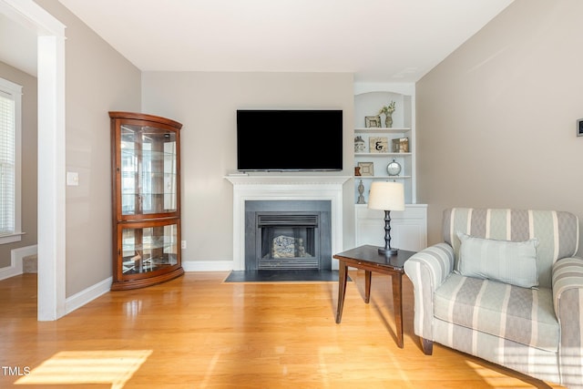 605 Bellefont Ct, Knightdale, NC 27545 - living area with light wood-style flooring, a fireplace with flush hearth, and built in features