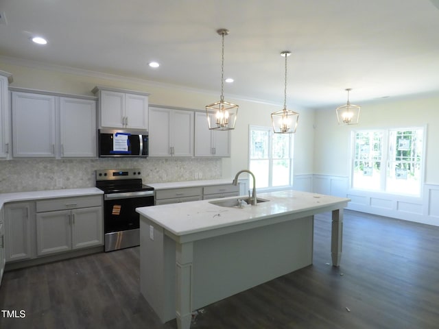 776 Shadetree Rd, Benson, NC 27504 - kitchen featuring appliances with stainless steel finishes, wainscoting, light countertops, dark wood-type flooring, and a center island with sink