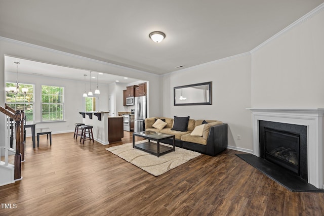 3810 Prince Noah Loop, Wake Forest, NC 27587 - living area with dark wood-style floors, crown molding, a chandelier, and a fireplace with raised hearth