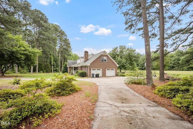 100 Martindale Dr, Youngsville, NC 27596 - view of front of property with brick siding, driveway, a chimney, and a garage