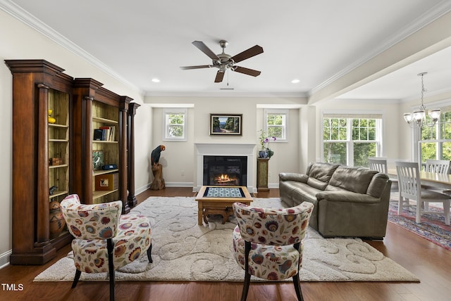 610 Chronicle Dr, Cary, NC 27513 - living room featuring healthy amount of natural light, a chandelier, a glass covered fireplace, a ceiling fan, and crown molding