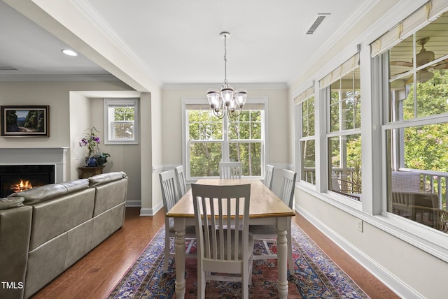 610 Chronicle Dr, Cary, NC 27513 - dining area featuring a chandelier, ornamental molding, dark wood finished floors, a lit fireplace, and recessed lighting
