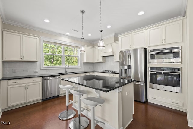 610 Chronicle Dr, Cary, NC 27513 - kitchen with stainless steel appliances, white cabinets, dark wood finished floors, backsplash, and decorative light fixtures