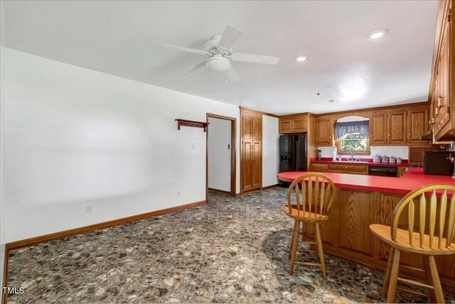 140 Maryland Dr, Manson, NC 27553 - kitchen featuring black appliances, ceiling fan, a peninsula, brown cabinetry, and a breakfast bar