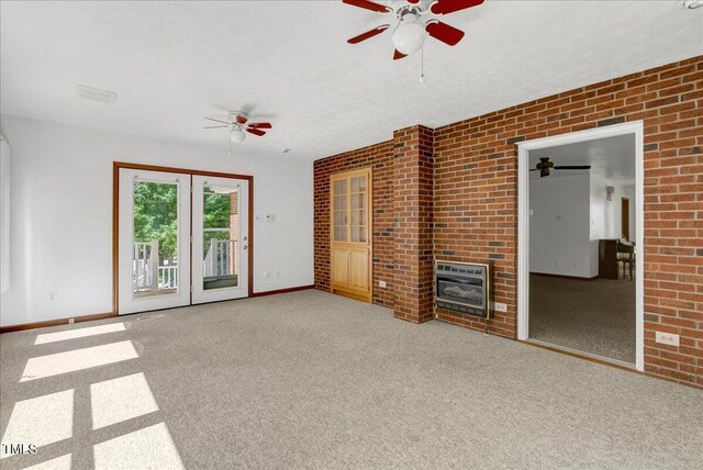 140 Maryland Dr, Manson, NC 27553 - unfurnished living room with heating unit, a ceiling fan, carpet, a glass covered fireplace, and brick wall
