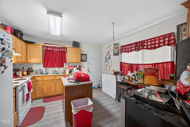 308 E Gilbreath St, Graham, NC 27253 - kitchen with white appliances, light countertops, light wood-style floors, a kitchen island, and a textured ceiling