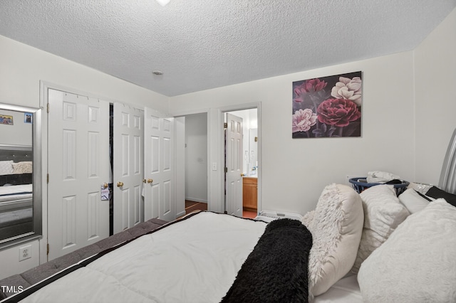 308 E Gilbreath St, Graham, NC 27253 - bedroom featuring a textured ceiling and connected bathroom
