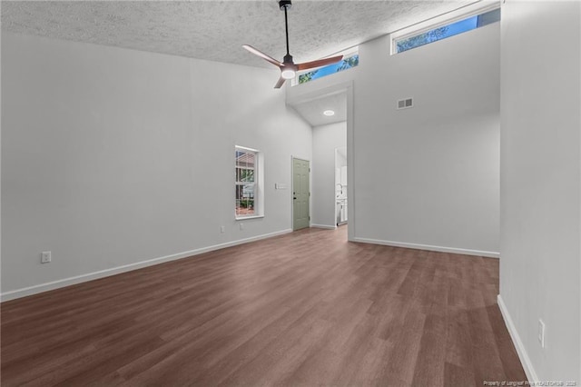 12741 Birchwood Cir, Laurinburg, NC 28352 - unfurnished room with a towering ceiling, wood finished floors, a textured ceiling, plenty of natural light, and ceiling fan