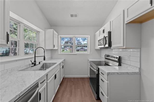 12741 Birchwood Cir, Laurinburg, NC 28352 - kitchen featuring appliances with stainless steel finishes, dark wood-style floors, light countertops, healthy amount of natural light, and a textured ceiling