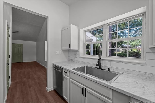 12741 Birchwood Cir, Laurinburg, NC 28352 - kitchen with stainless steel dishwasher, dark wood-style flooring, healthy amount of natural light, lofted ceiling, and white cabinetry