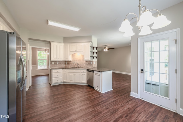 2430 Josephine Rd, Garner, NC 27529 - kitchen with stainless steel appliances, a peninsula, a chandelier, decorative backsplash, and white cabinets