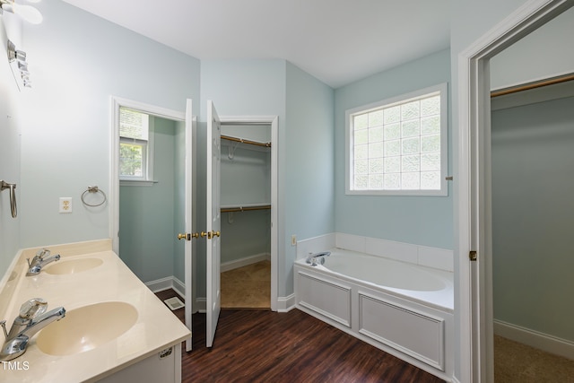2430 Josephine Rd, Garner, NC 27529 - full bathroom with a bath, a walk in closet, plenty of natural light, and wood finished floors