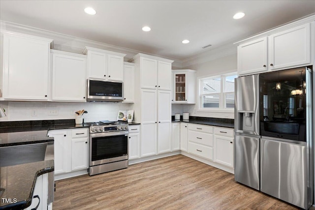 1125 Russet Ln, Apex, NC 27523 - kitchen with stainless steel appliances, ornamental molding, white cabinetry, light wood finished floors, and tasteful backsplash