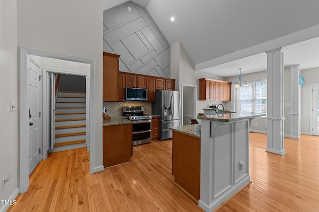 2813 Greenridge View Ln, Zebulon, NC 27597 - kitchen with stainless steel appliances, ornate columns, lofted ceiling, a kitchen breakfast bar, and dark stone countertops