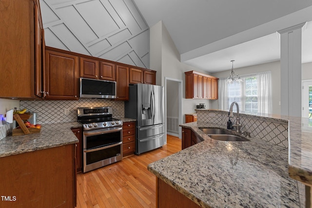 2813 Greenridge View Ln, Zebulon, NC 27597 - kitchen featuring appliances with stainless steel finishes, backsplash, light wood-type flooring, light stone counters, and lofted ceiling