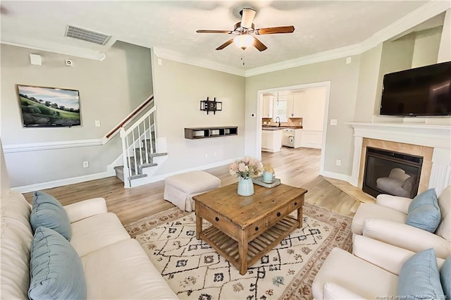 37 Annapolis Rd, Cameron, NC 28326 - living area with light wood finished floors, stairs, a ceiling fan, crown molding, and a tile fireplace