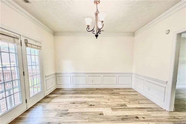 37 Annapolis Rd, Cameron, NC 28326 - unfurnished dining area featuring ornamental molding, a chandelier, light wood finished floors, a textured ceiling, and a wainscoted wall