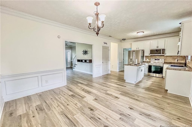 37 Annapolis Rd, Cameron, NC 28326 - kitchen with stainless steel appliances, ornamental molding, a kitchen island, a chandelier, and white cabinetry