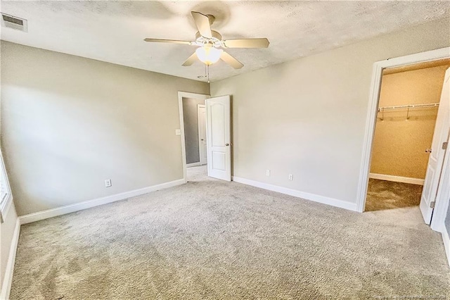 37 Annapolis Rd, Cameron, NC 28326 - unfurnished bedroom featuring carpet flooring, a spacious closet, ceiling fan, and a textured ceiling