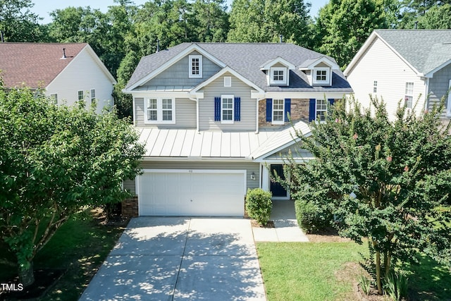 418 Byrams Ford Dr, Cary, NC 27513 - view of front of house featuring stone siding, a standing seam roof, driveway, and an attached garage