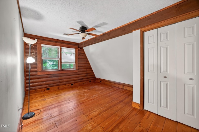 3263 S Jim Minor Rd, Haw River, NC 27258 - unfurnished bedroom with rustic walls, a textured ceiling, hardwood / wood-style floors, a closet, and ceiling fan