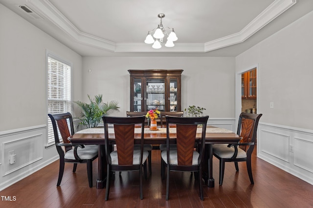 308 Sutton Glen Dr, Apex, NC 27523 - dining room featuring a chandelier, a raised ceiling, ornamental molding, wainscoting, and dark wood finished floors