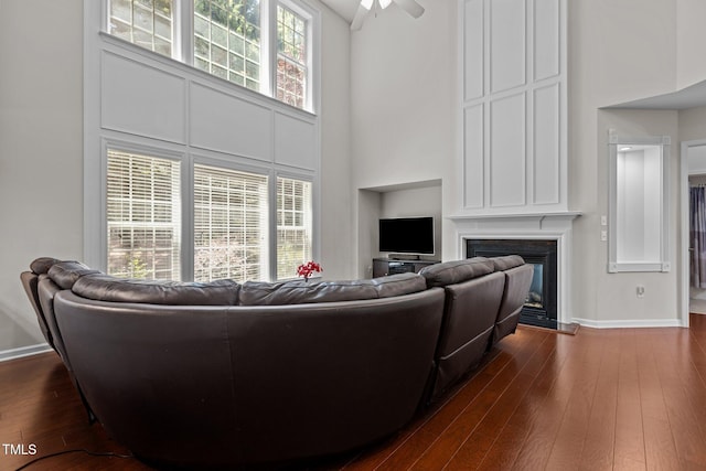 308 Sutton Glen Dr, Apex, NC 27523 - living area featuring a high ceiling, dark wood-type flooring, a glass covered fireplace, and ceiling fan
