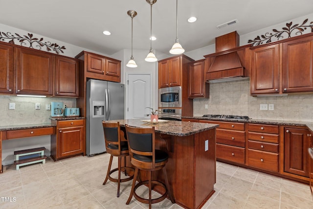 308 Sutton Glen Dr, Apex, NC 27523 - kitchen with stainless steel appliances, backsplash, dark stone countertops, custom range hood, and pendant lighting