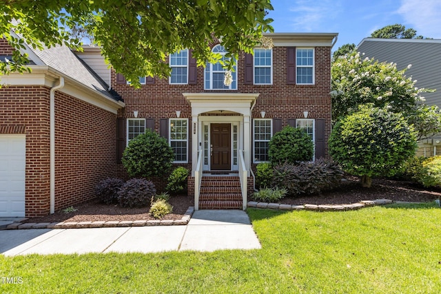 308 Sutton Glen Dr, Apex, NC 27523 - colonial home with brick siding, a front lawn, and a garage