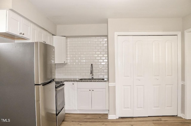621 Reservoir St, Durham, NC 27703 - kitchen featuring stainless steel appliances, light wood-style floors, white cabinets, and decorative backsplash