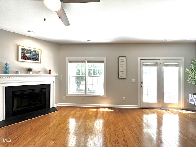 2069 White Pond Ct, Apex, NC 27523 - unfurnished living room featuring wood finished floors, a fireplace with flush hearth, and a ceiling fan