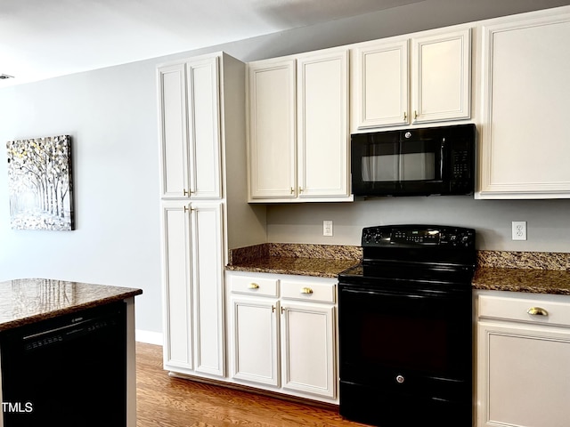 2069 White Pond Ct, Apex, NC 27523 - kitchen with black appliances, dark stone countertops, light wood finished floors, and white cabinetry