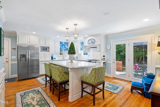 1610 Ridge Rd, Raleigh, NC 27607 - kitchen featuring stainless steel appliances, light countertops, decorative backsplash, crown molding, and white cabinetry