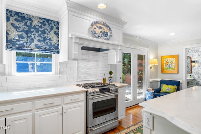1610 Ridge Rd, Raleigh, NC 27607 - kitchen with stainless steel gas stove, healthy amount of natural light, crown molding, tasteful backsplash, and wood finished floors