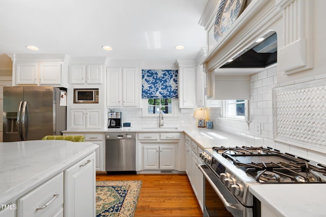 1610 Ridge Rd, Raleigh, NC 27607 - kitchen with stainless steel appliances, decorative backsplash, white cabinetry, light wood-style floors, and recessed lighting