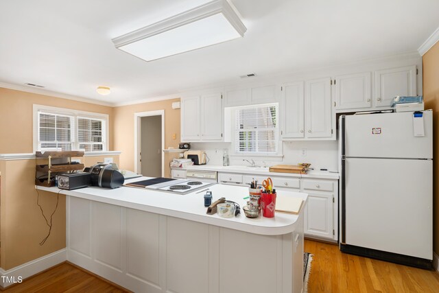 1610 Ridge Rd, Raleigh, NC 27607 - kitchen with white appliances, light countertops, a peninsula, crown molding, and white cabinetry