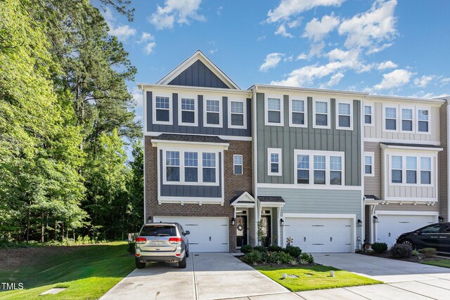 2866 Hunter Woods Dr, Apex, NC 27502 - view of front of home featuring board and batten siding, brick siding, driveway, a garage, and a front lawn