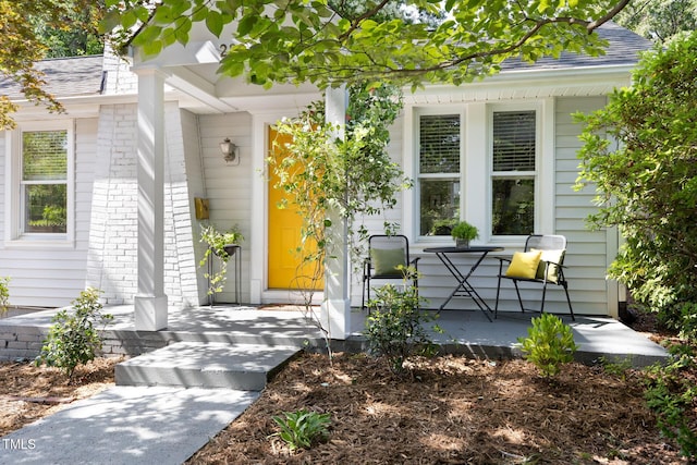 2804 Barmettler St, Raleigh, NC 27607 - entrance to property with covered porch, roof with shingles, and brick siding