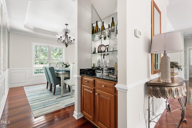 5106 Stockton Way, Durham, NC 27707 - bar area featuring dark wood finished floors, crown molding, and a chandelier
